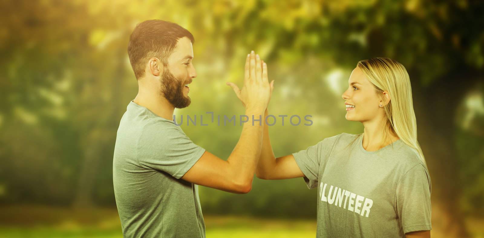 Composite image of smiling volunteer doing high five in office by Wavebreakmedia