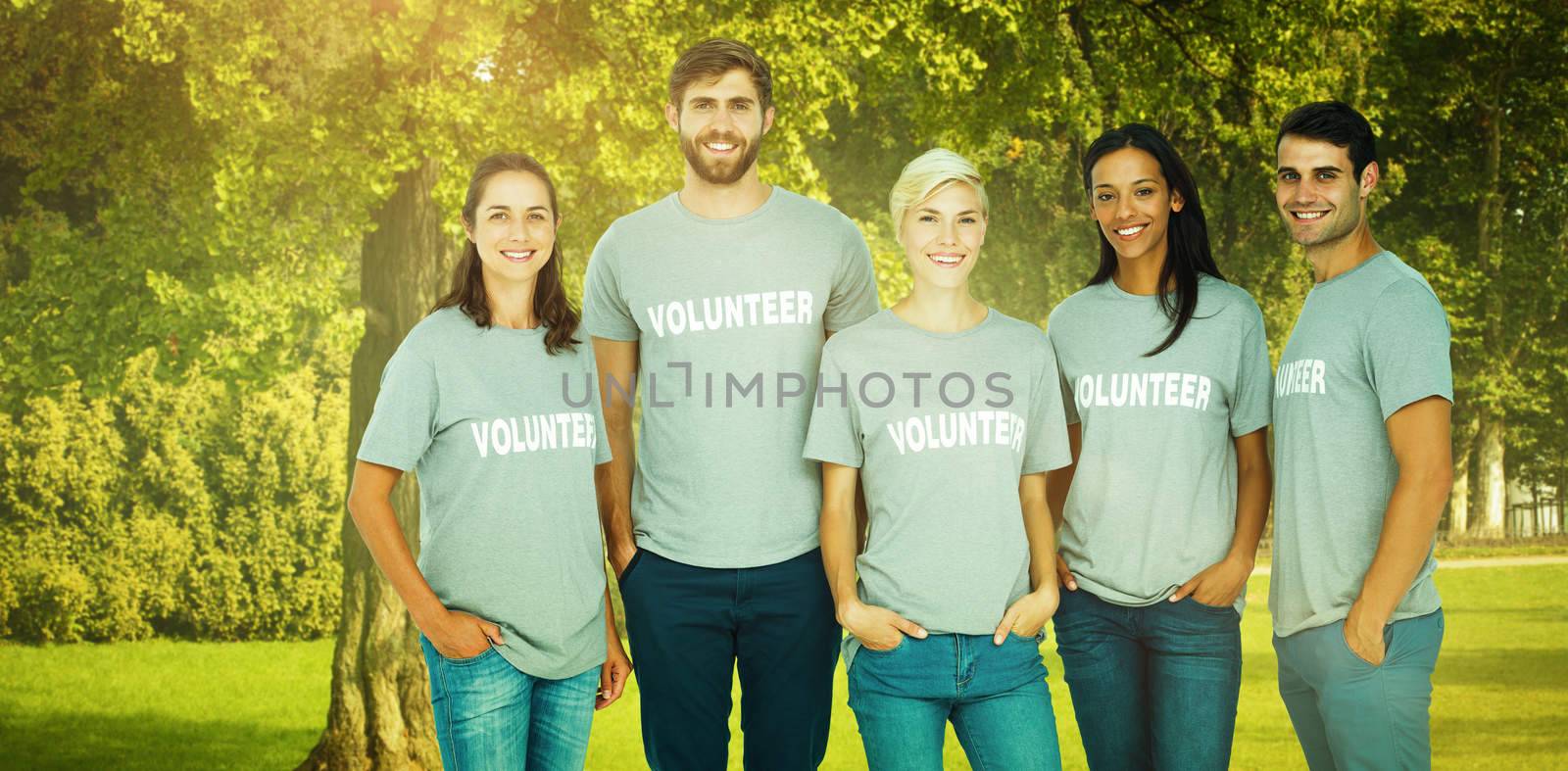 Volunteers friends smiling at the camera against trees and meadow