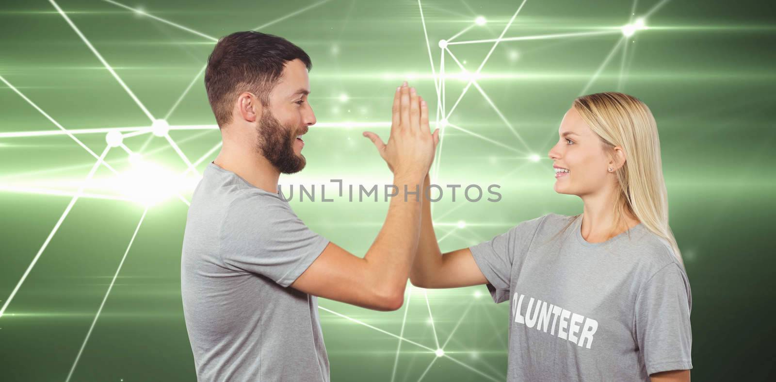 Composite image of smiling volunteer doing high five in office by Wavebreakmedia