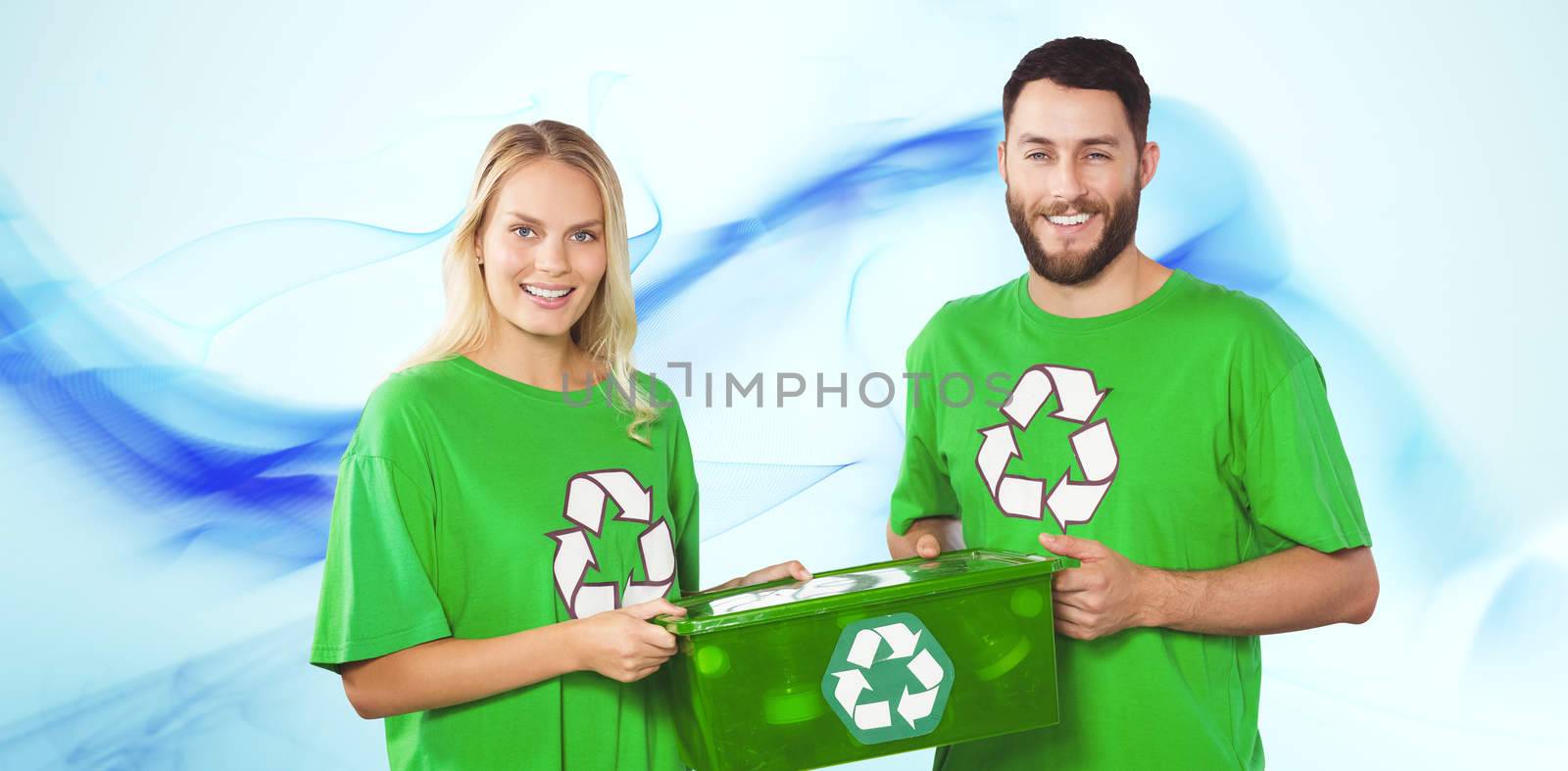 Portrait of smiling volunteers carrying recycling container  against blue abstract design