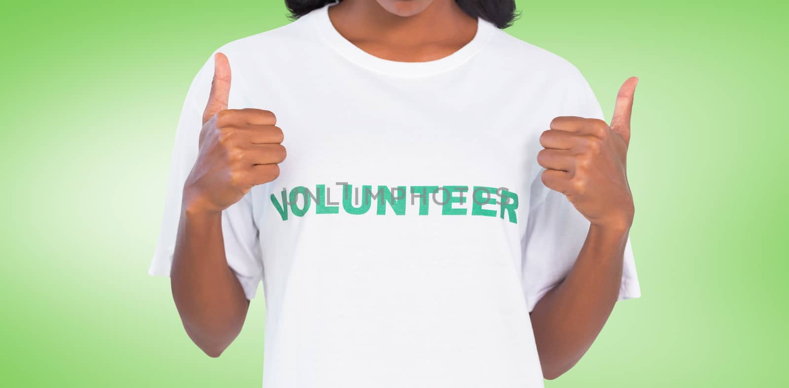 Woman wearing volunteer tshirt and giving thumbs up against green vignette