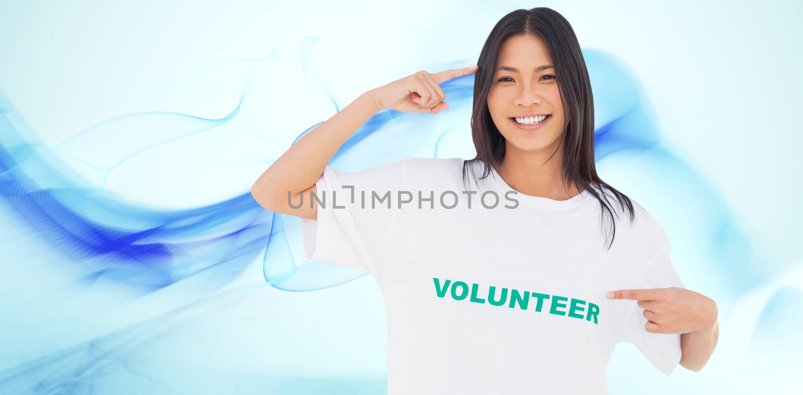 Smiling woman pointing to her volunteer tshirt against blue abstract design