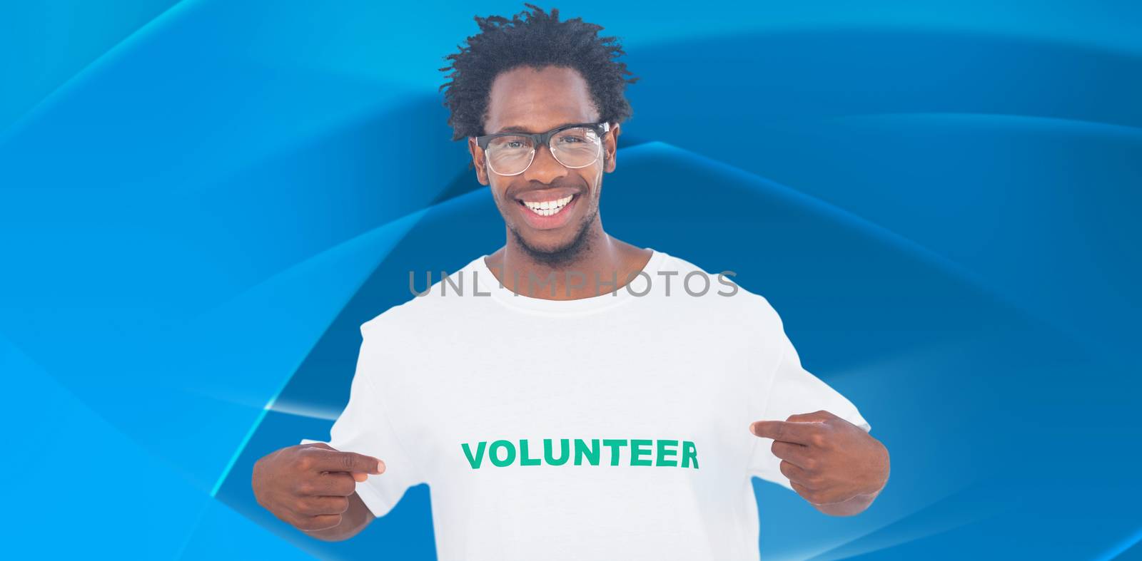 Handsome man pointing to his volunteer tshirt against abstract blue design