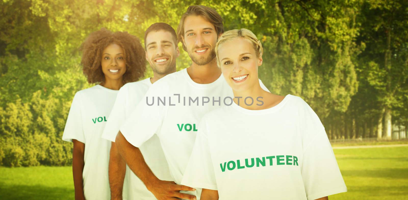 Smiling volunteer group against trees and meadow