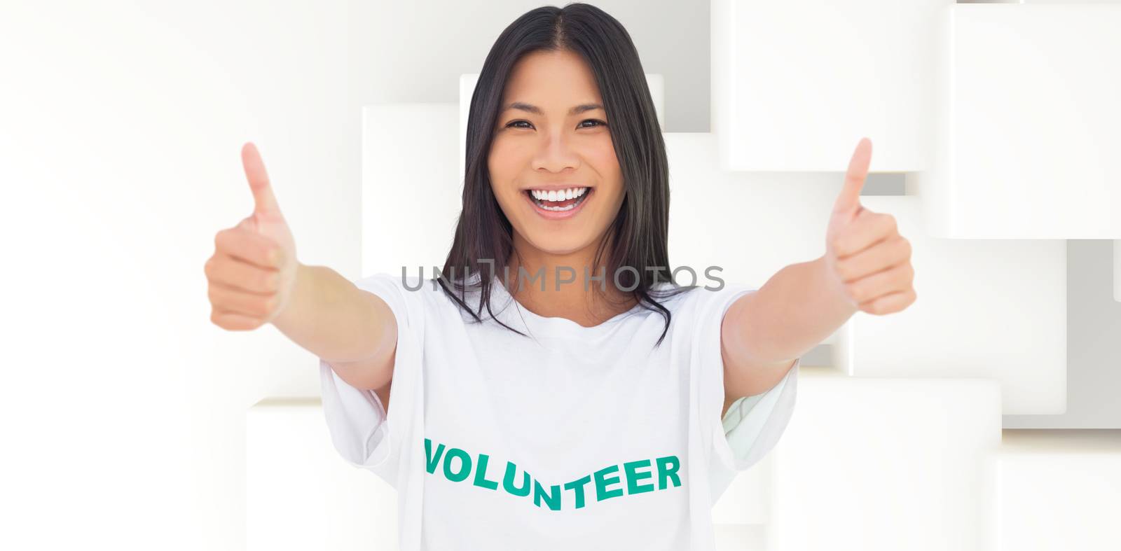 Composite image of woman wearing volunteer tshirt giving thumbs up by Wavebreakmedia