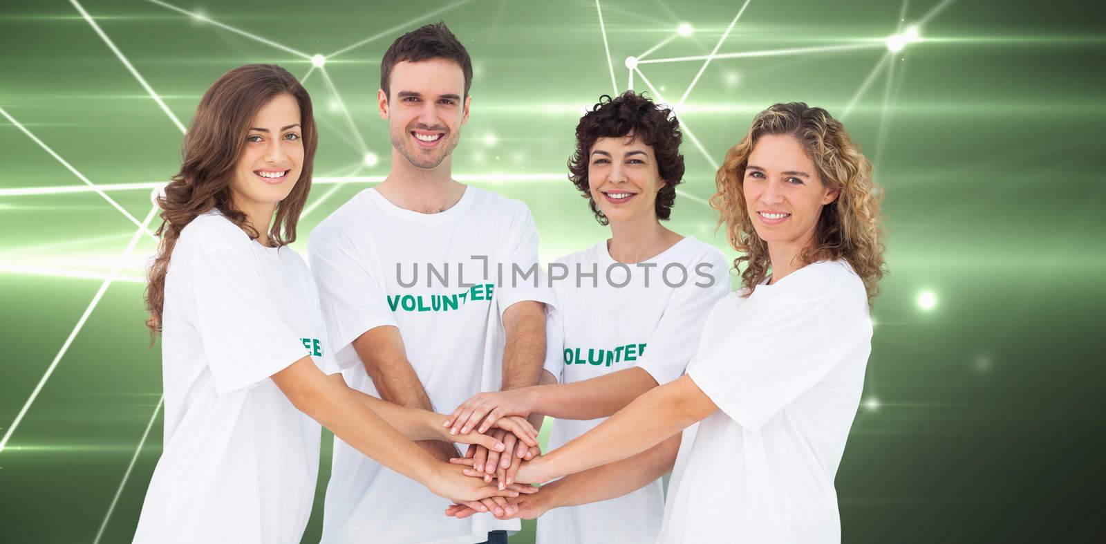 Composite image of smiling volunteer group piling up their hands by Wavebreakmedia