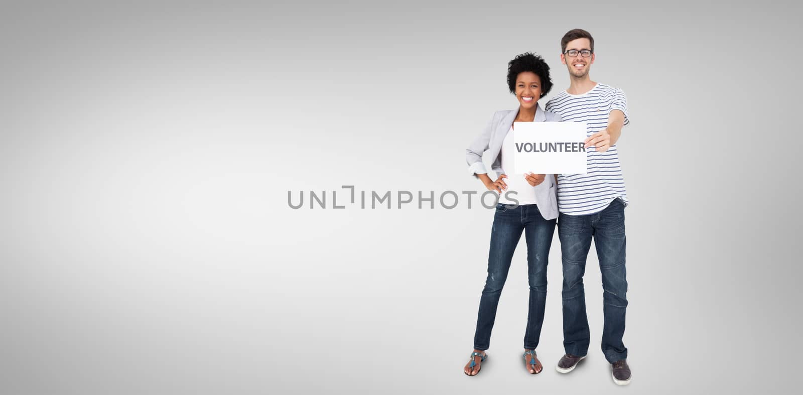 Portrait of a happy couple holding a volunteer note against grey vignette