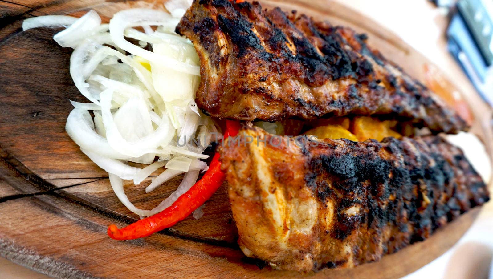 spare ribs in wooden tray with vegetables