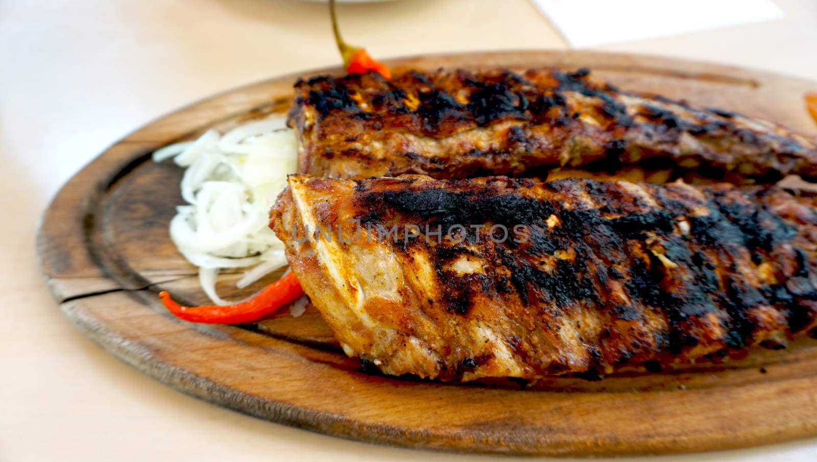 spare ribs in wooden plate with vegetables by polarbearstudio