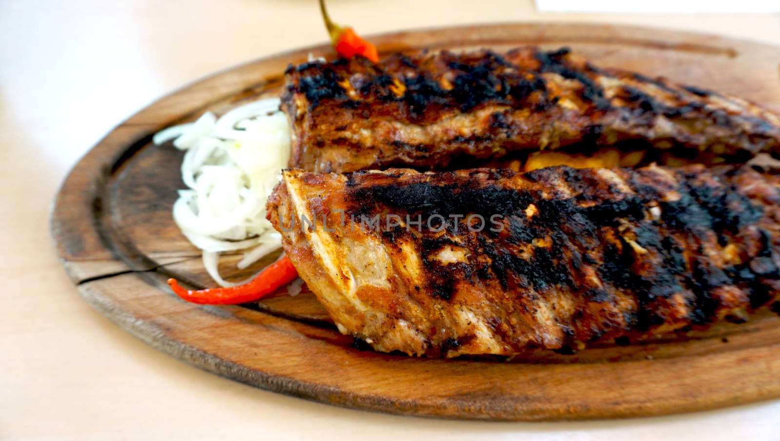 spare ribs in wooden tray with vegetables