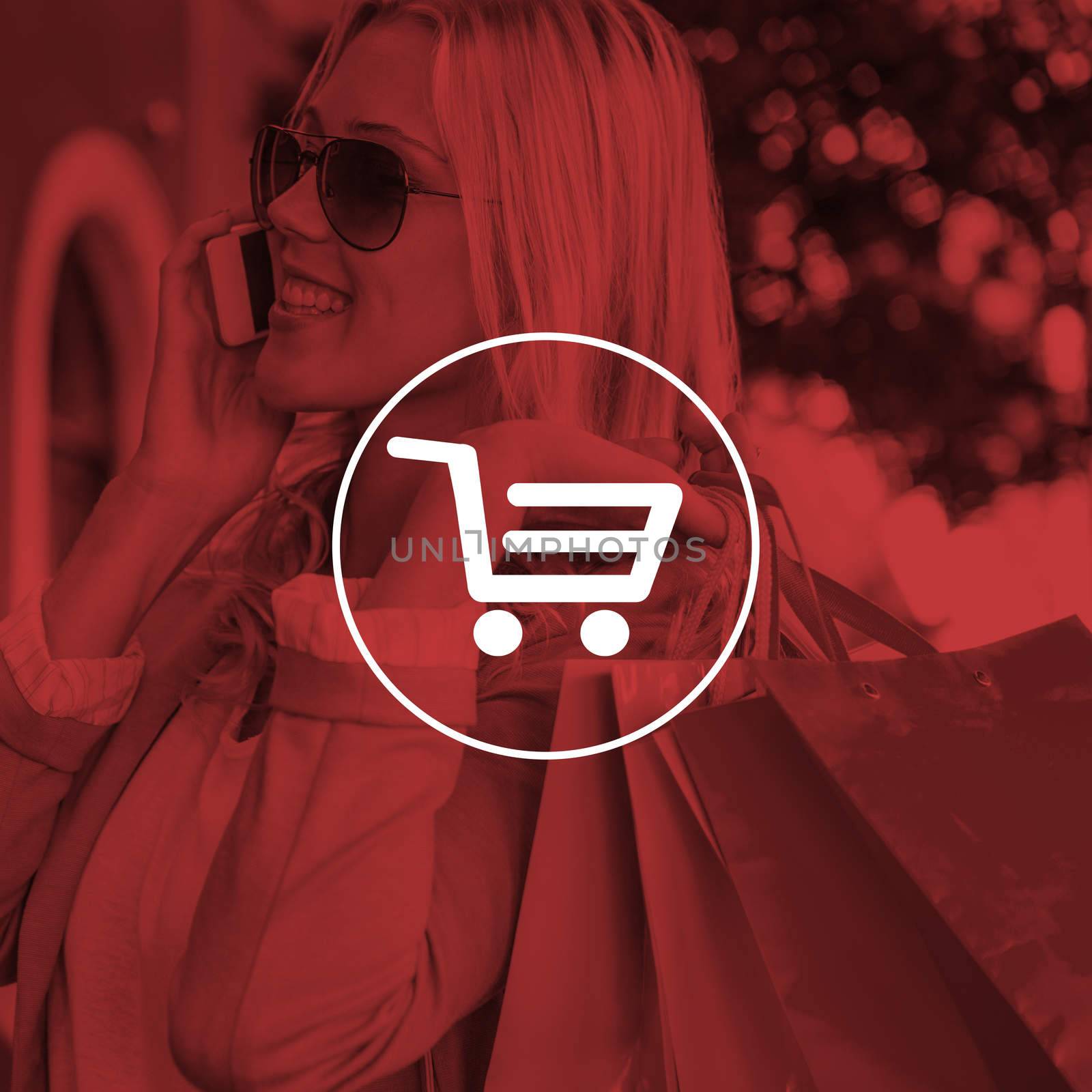 Pretty blonde talking on phone holding shopping bags against digital image of trolley