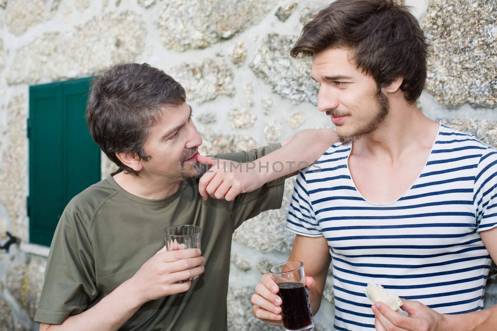 two friends having a drink and talking outdoors