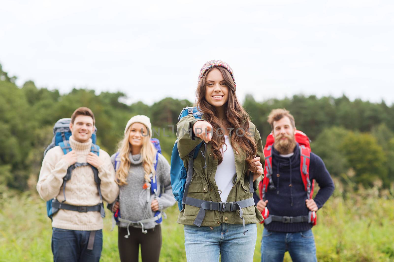 smiling hikers with backpacks pointing finger by dolgachov