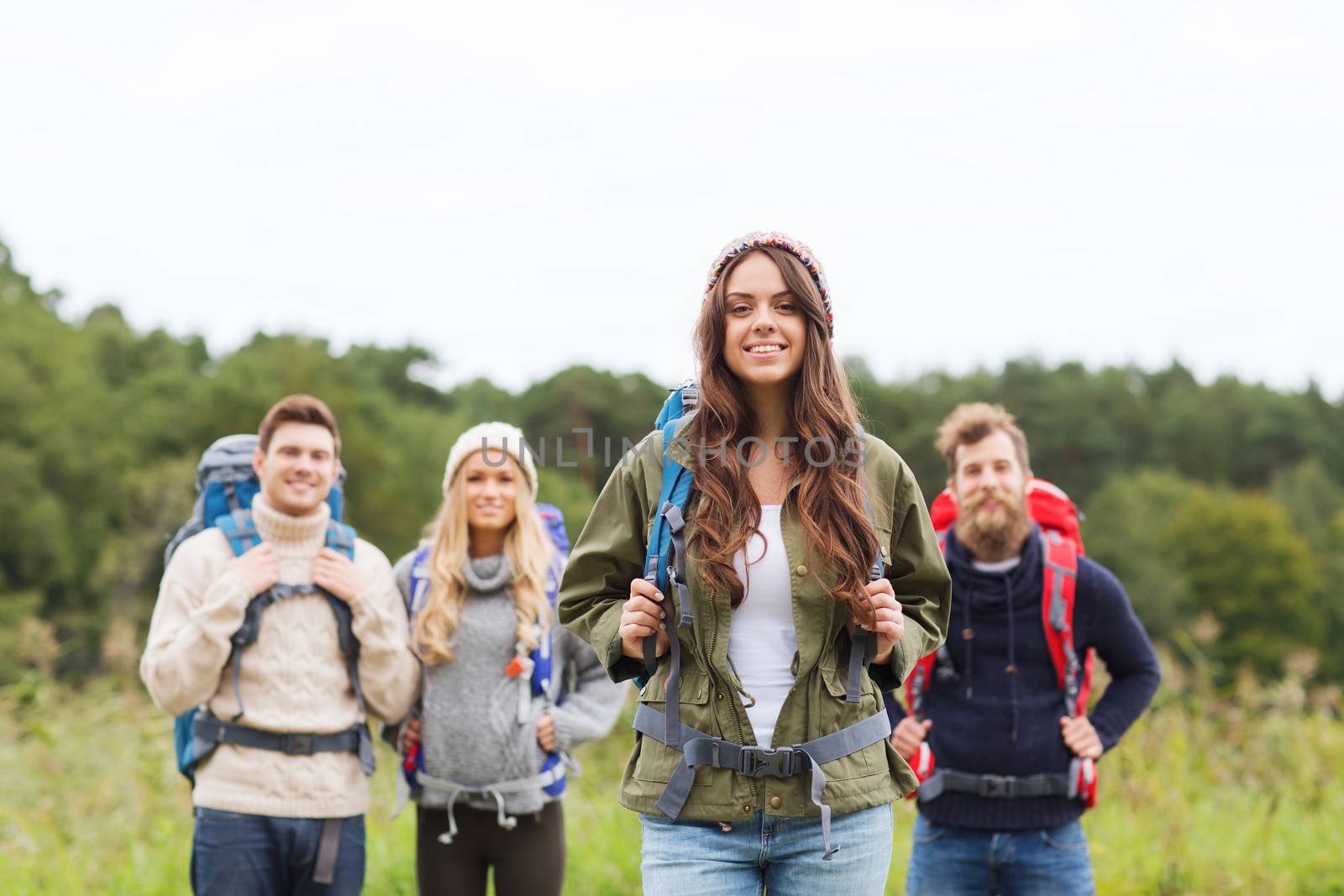 group of smiling friends with backpacks hiking by dolgachov