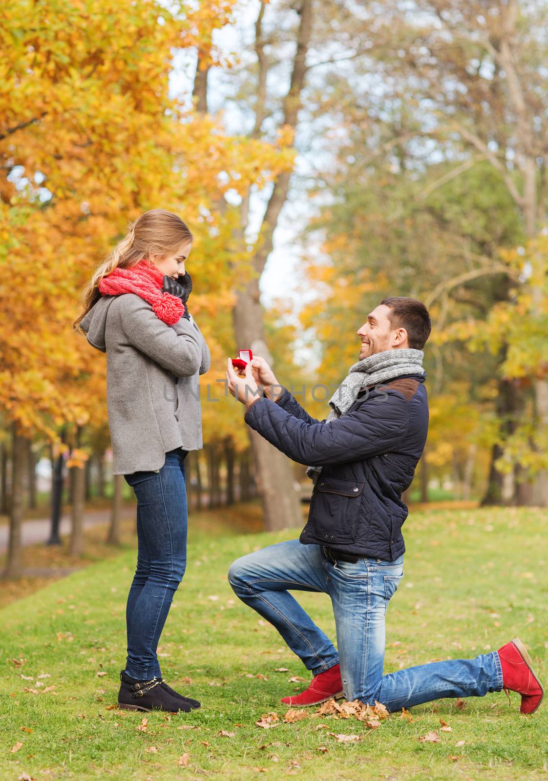 smiling couple with engagement ring in gift box by dolgachov
