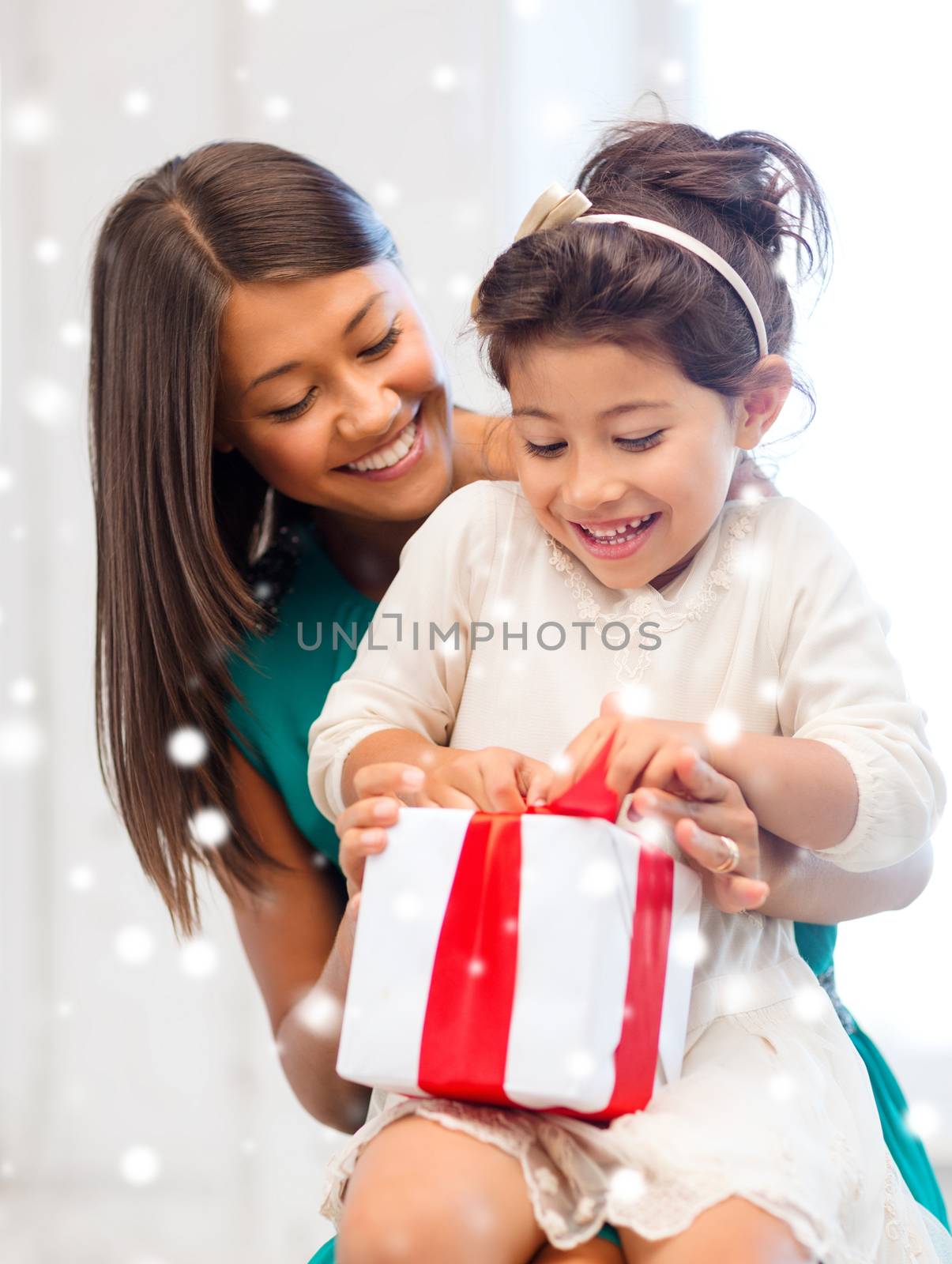 holidays, presents, christmas, x-mas concept - happy mother and child girl with gift box over snowy background