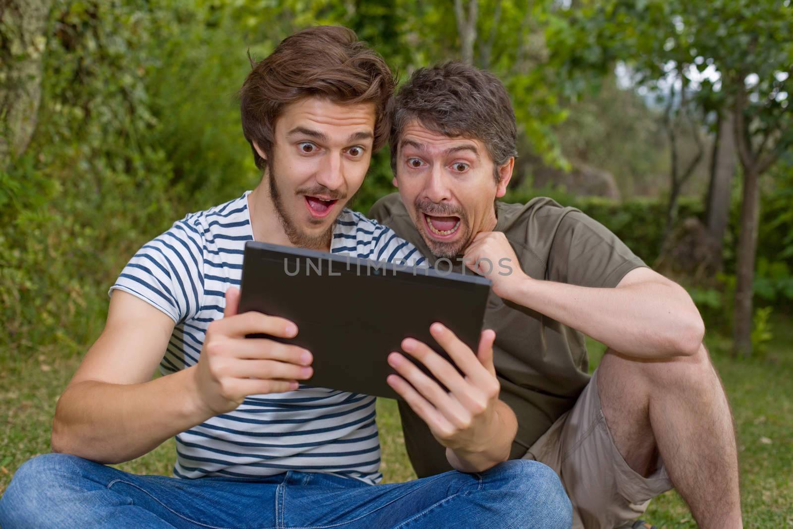 casual men surprised with a tablet pc, outdoor