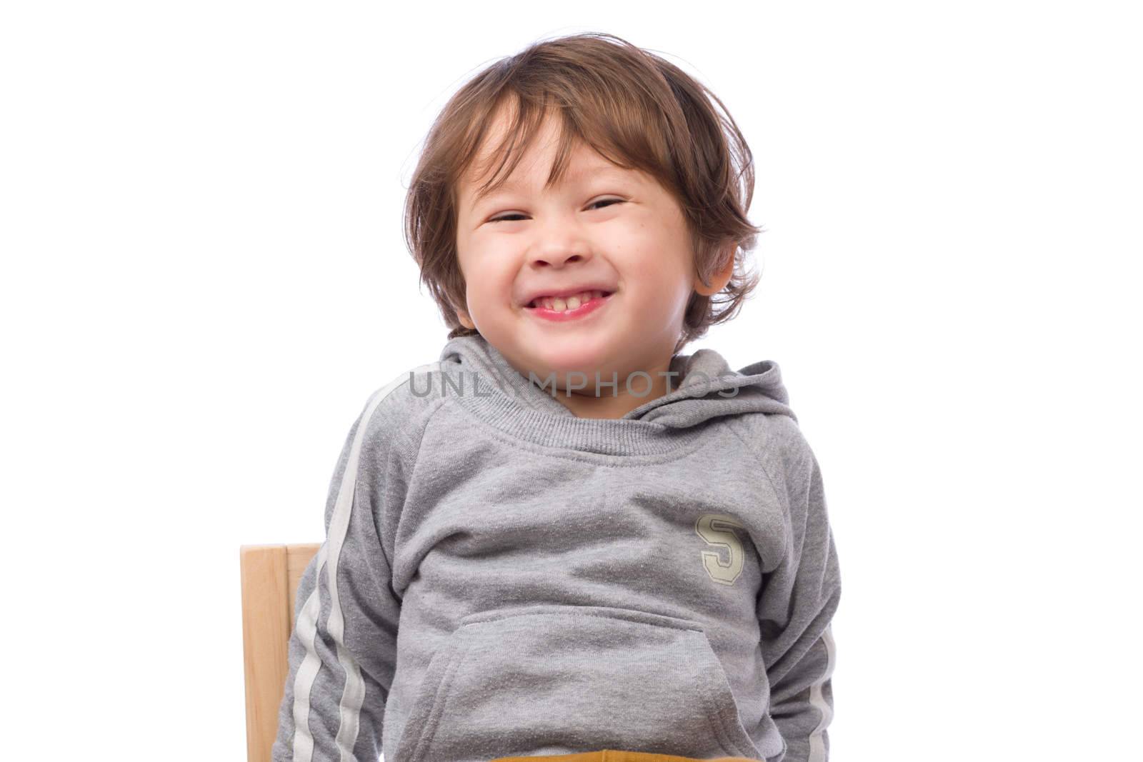 A cute 3 year old boy with a happy expression on a white background.