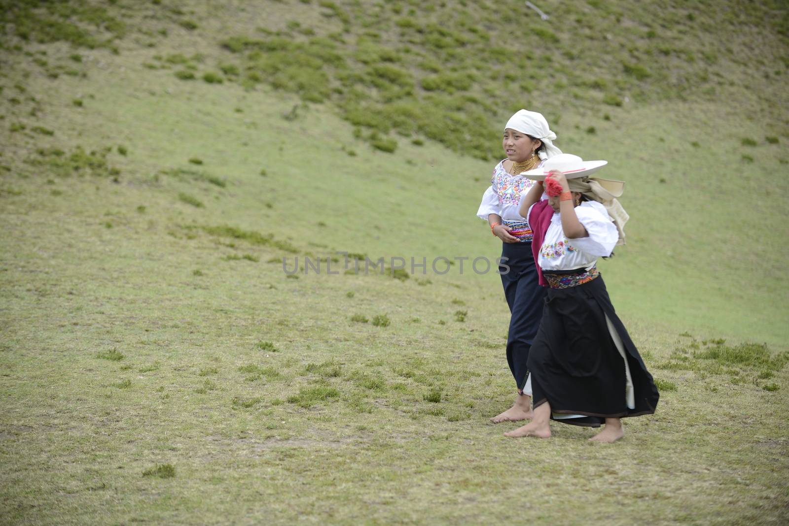 Cochasqui, Ecuador, - June, 2013. Two American Indians in traditional Ecuadorian costumes are having a rest between the participation in Solstice holiday. Their dancing is an important  part of the whole performance, in which shamans from different tribes of Latin America are participating.