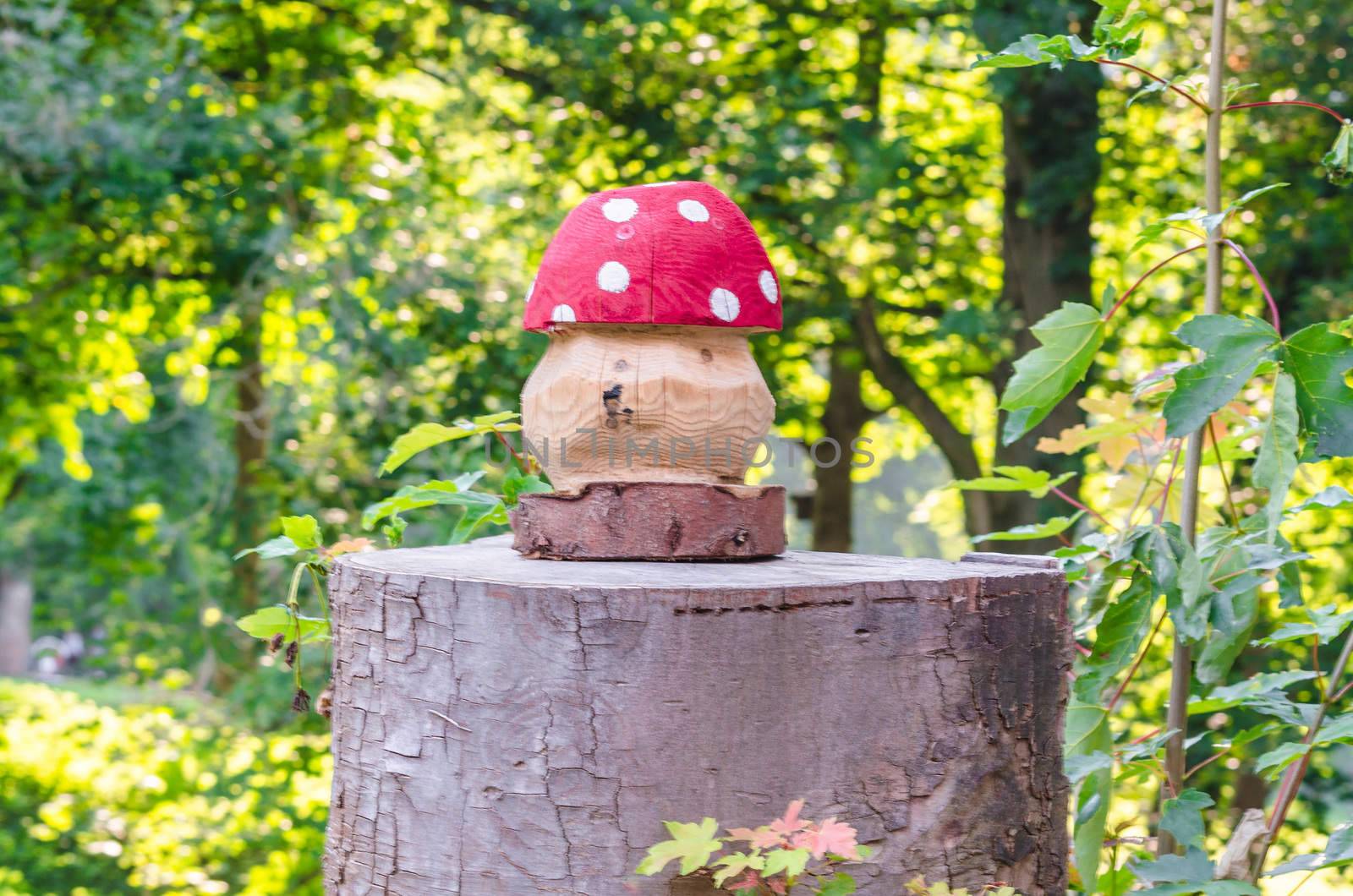 Fly agaric manufactured from wood on a tree trunk.