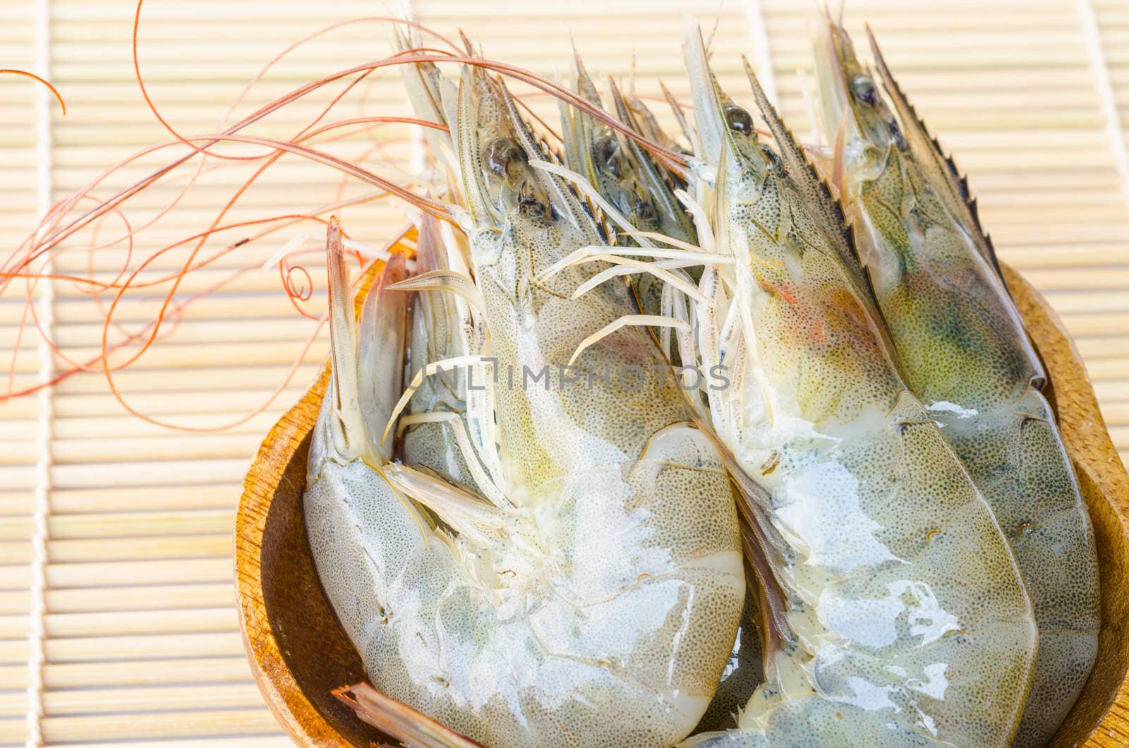 close up raw shrimps in cup on the wood background.