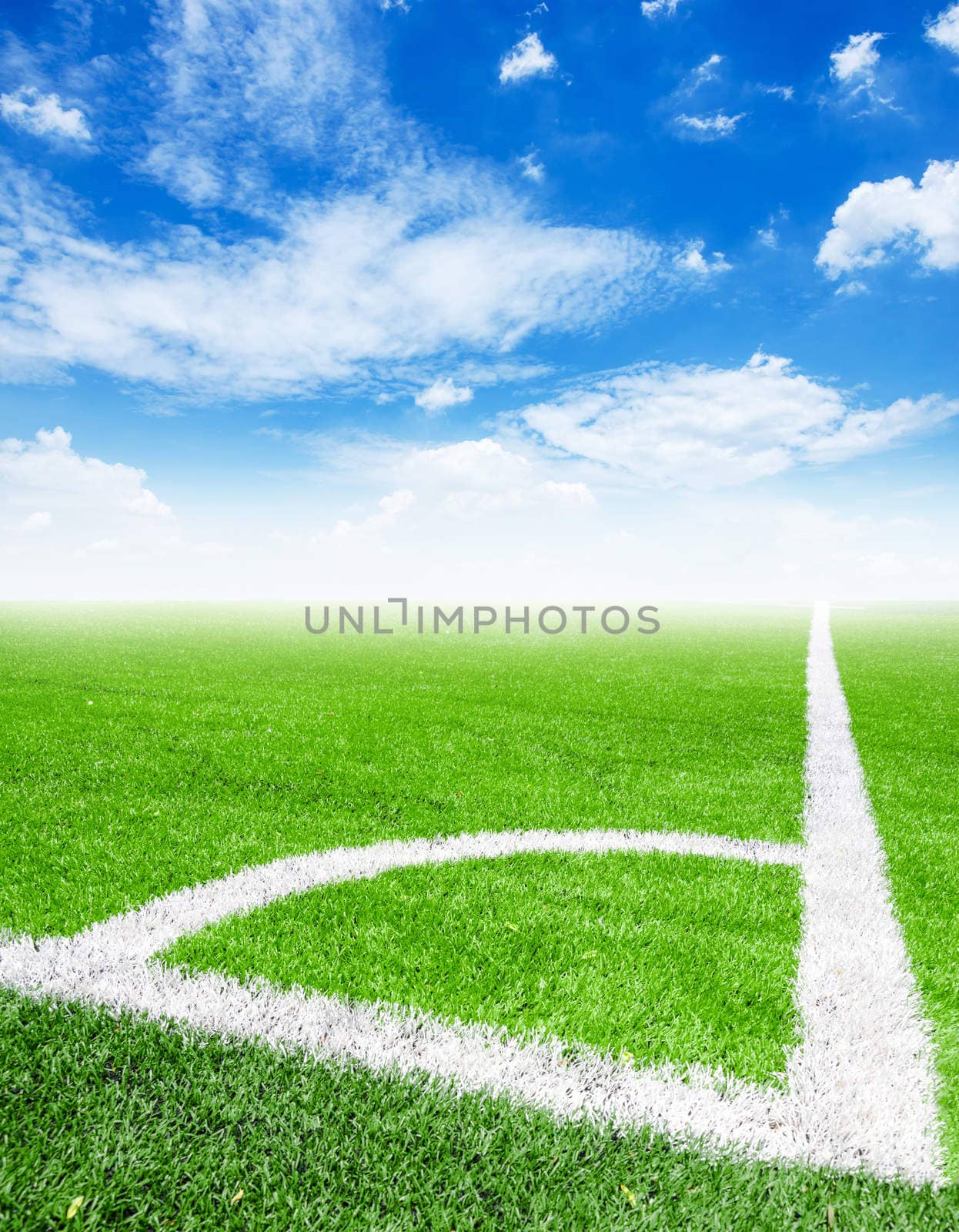 Soccer ball in corner kick position with blue sky.
