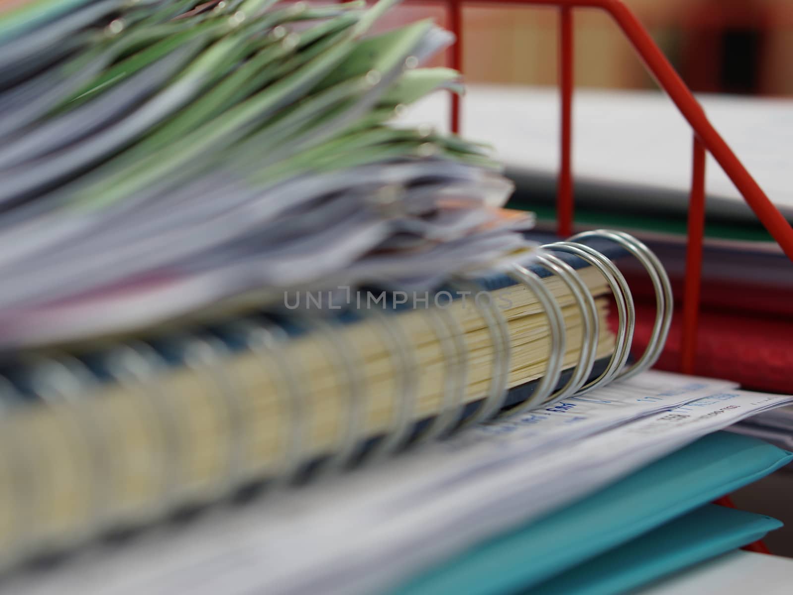 Pile of documents and blur notebook in basket at office.