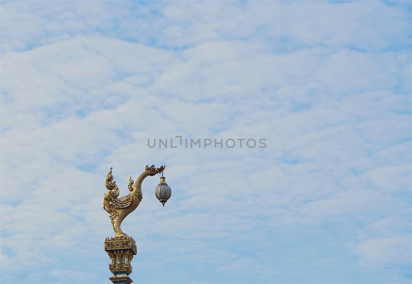 Thai traditional street lamp, beautiful golden swan on blue sky background.