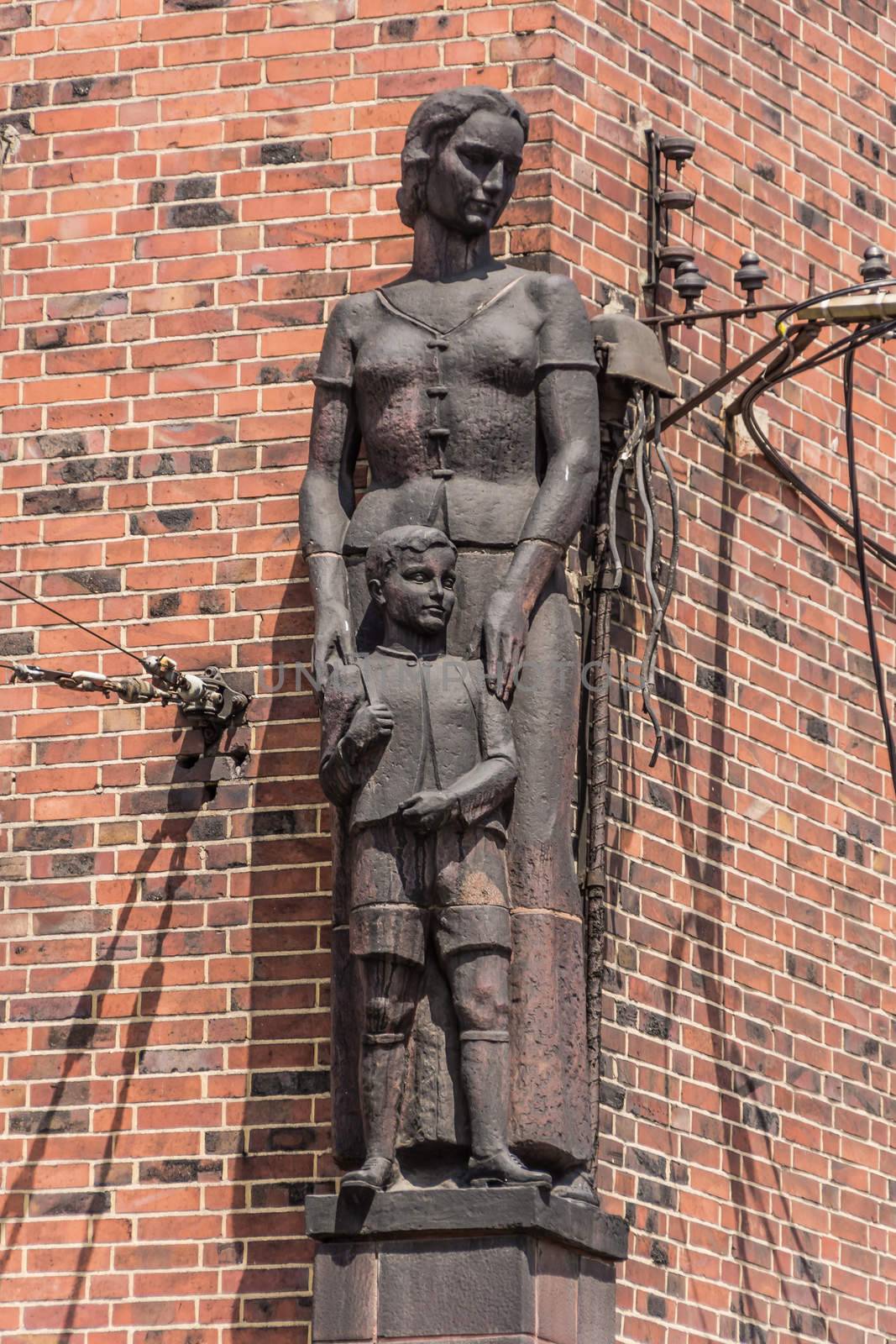 Statue of a woman with a boy by German artist Walter Tuckermann on the facade of the school in Byrom. Created in nazi realism style, survived untouched socialism times.