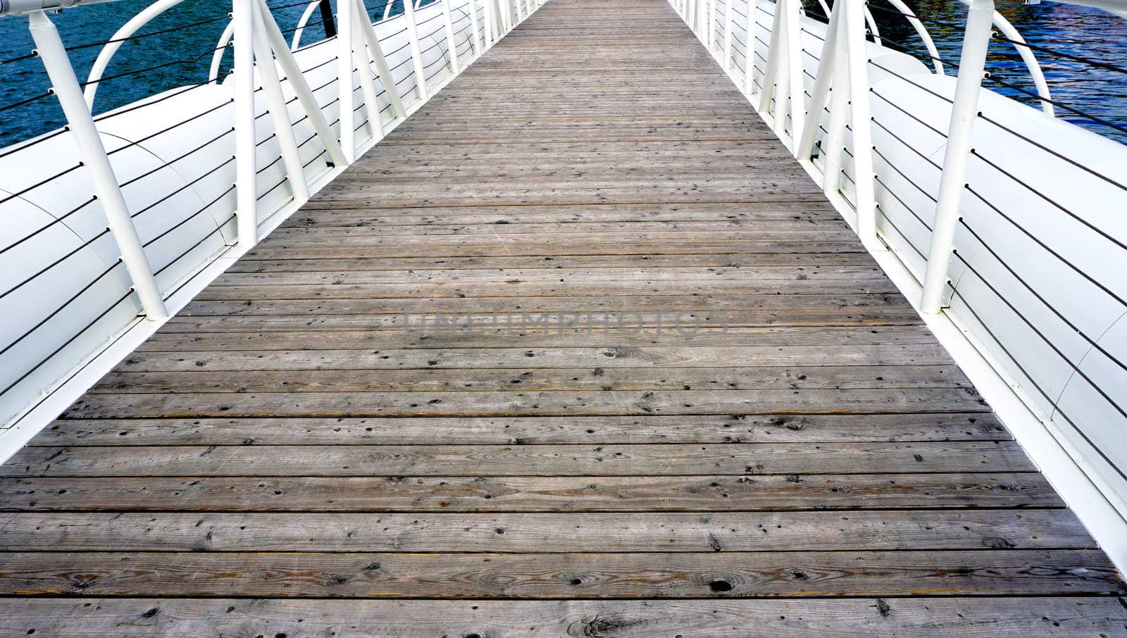 Wooden floor bridge and white railing over Danube river