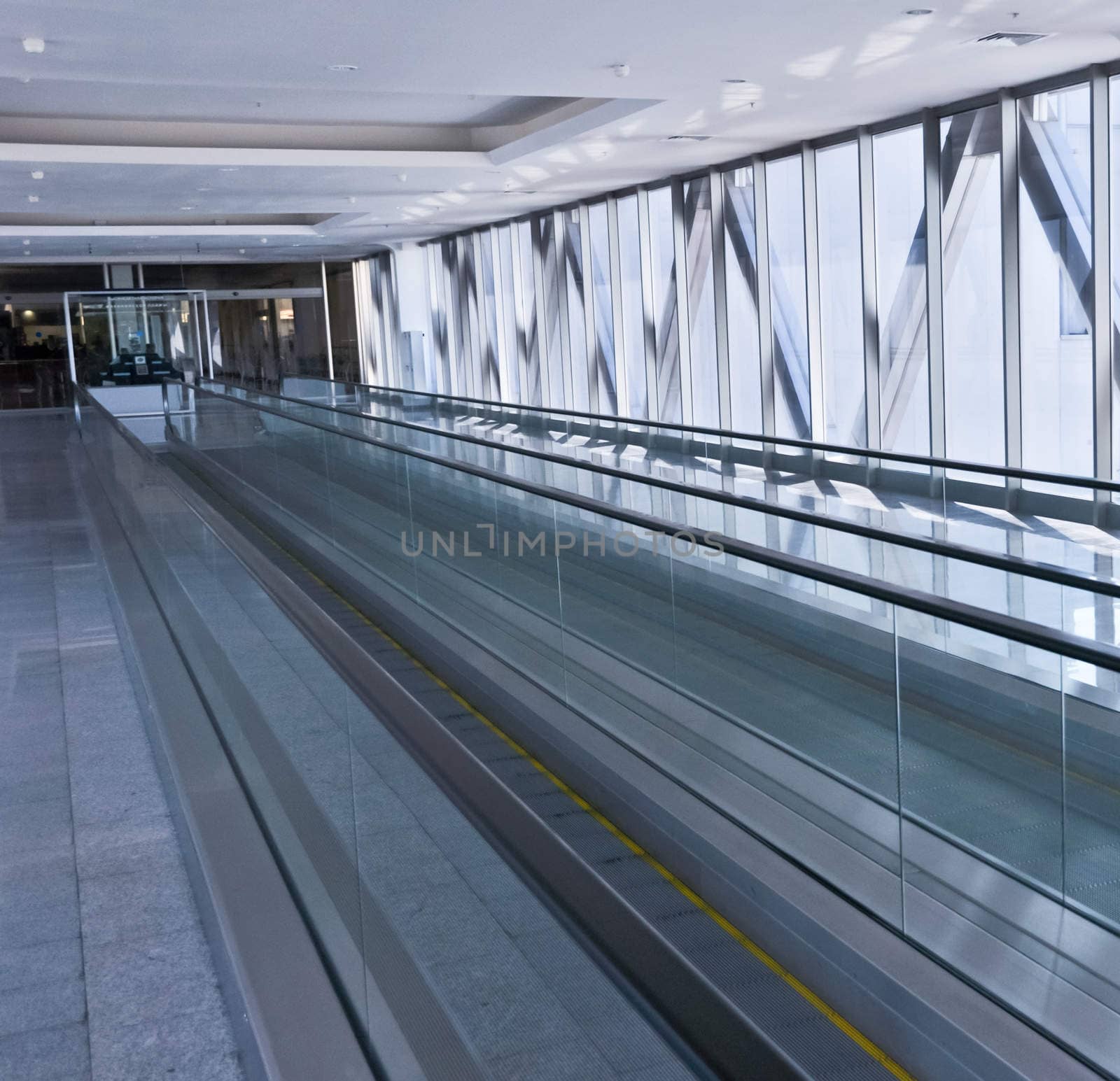 the empty escalator inside the contemporary building by vlaru