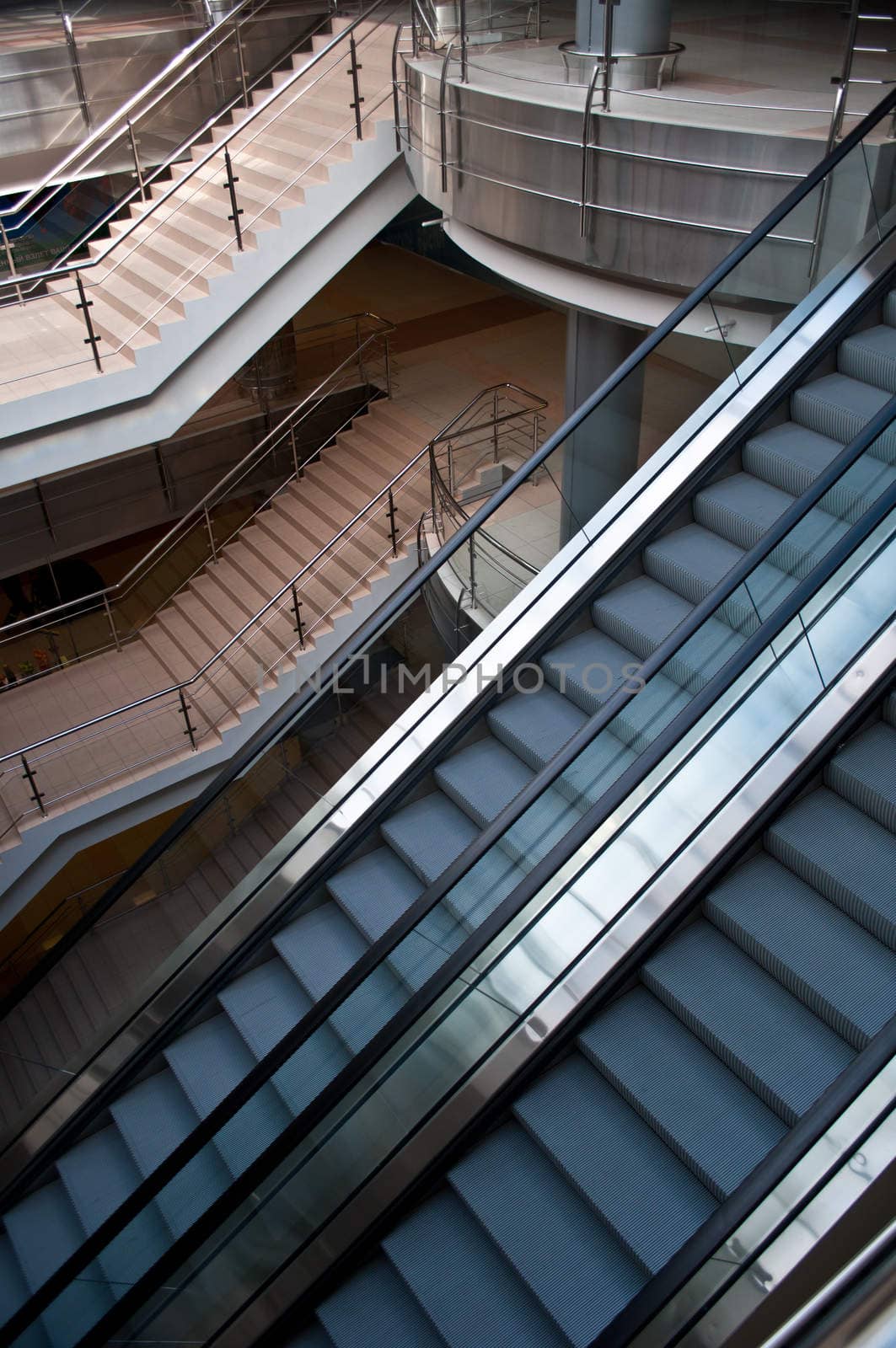 escalators and stairs in a modern office building by vlaru