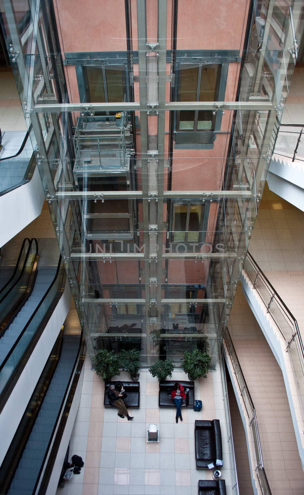 glass elevator shaft in a modern office building by vlaru