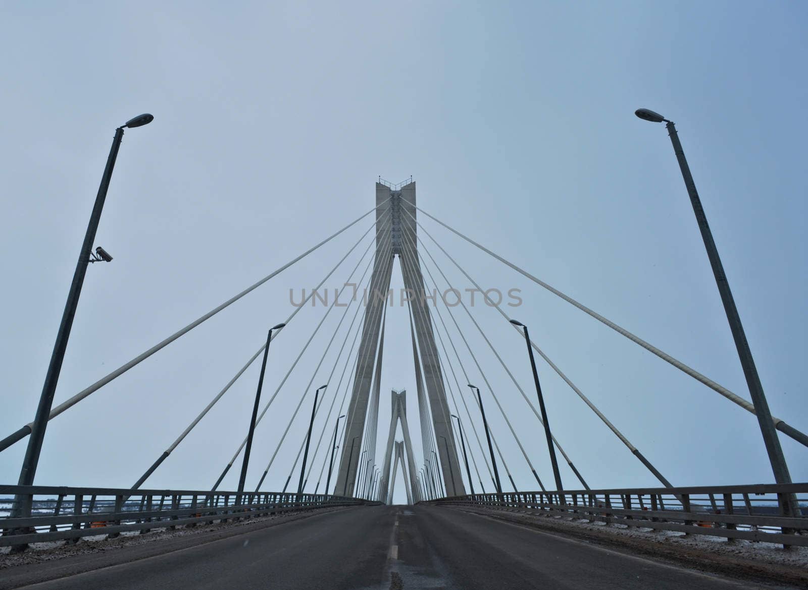 modern bridge across the river on a cloudy day by vlaru