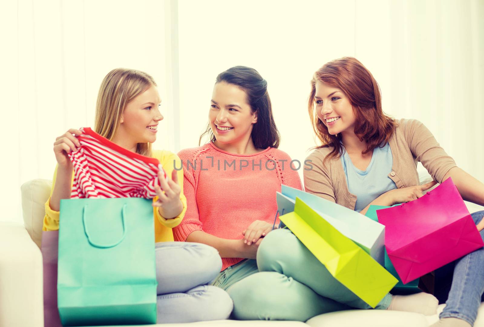 smiling teenage girls with many shopping bags by dolgachov