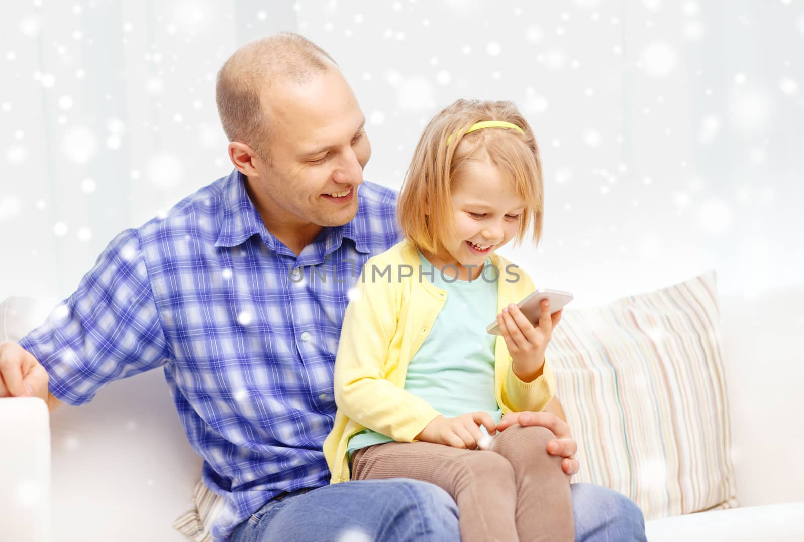 family, childhood, parenthood, technology and people concept - happy father and daughter with smartphone at home