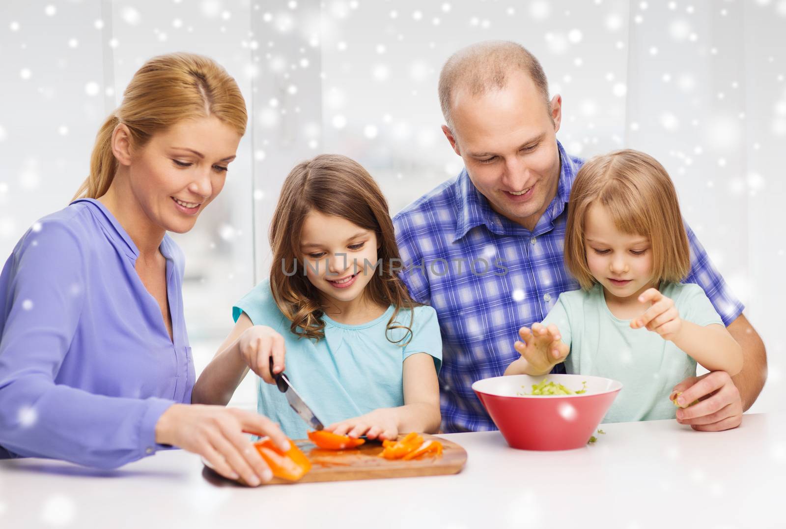 happy family with two kids making dinner at home by dolgachov