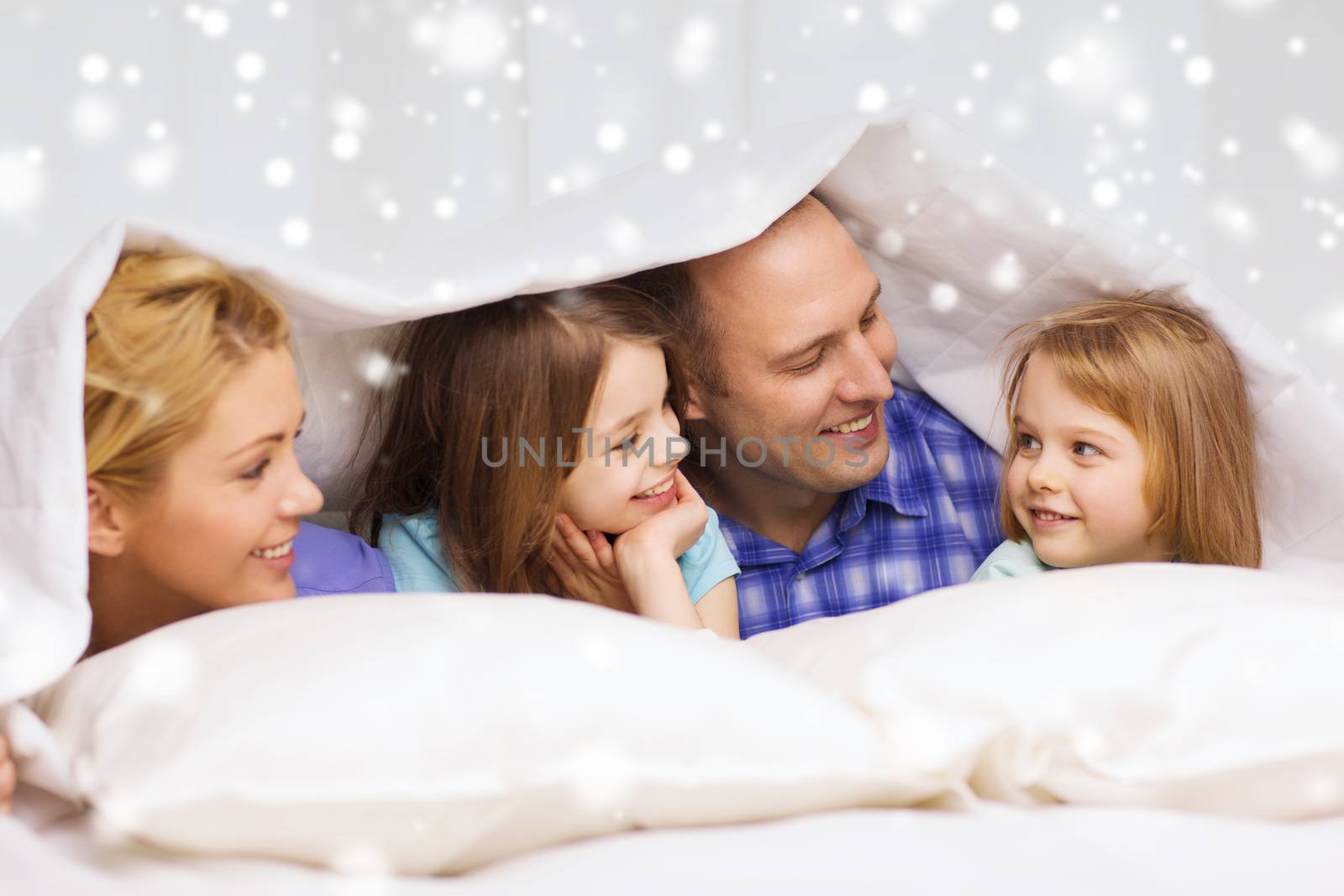 happy family with two kids under blanket at home by dolgachov