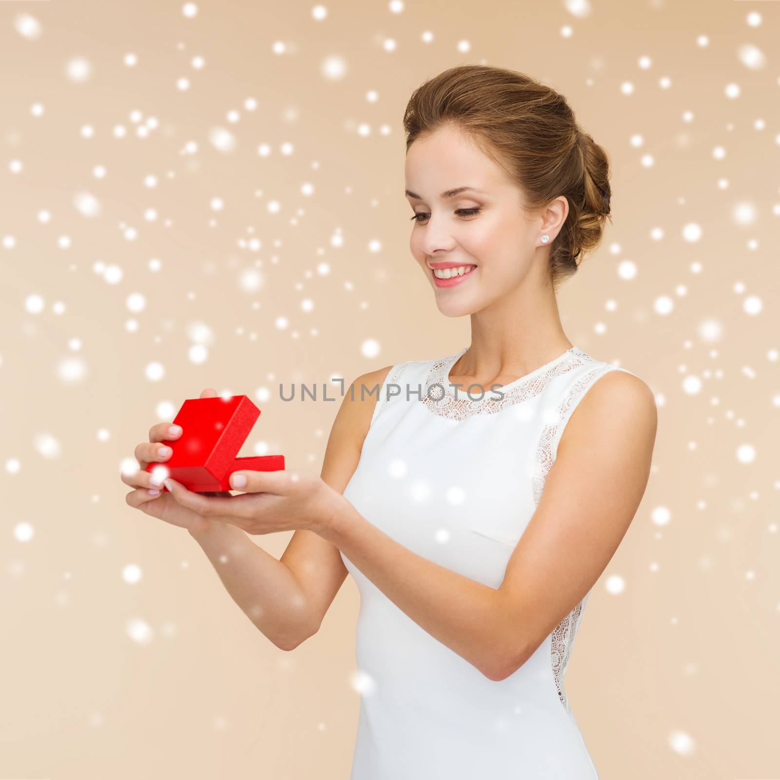 smiling woman holding red gift box by dolgachov
