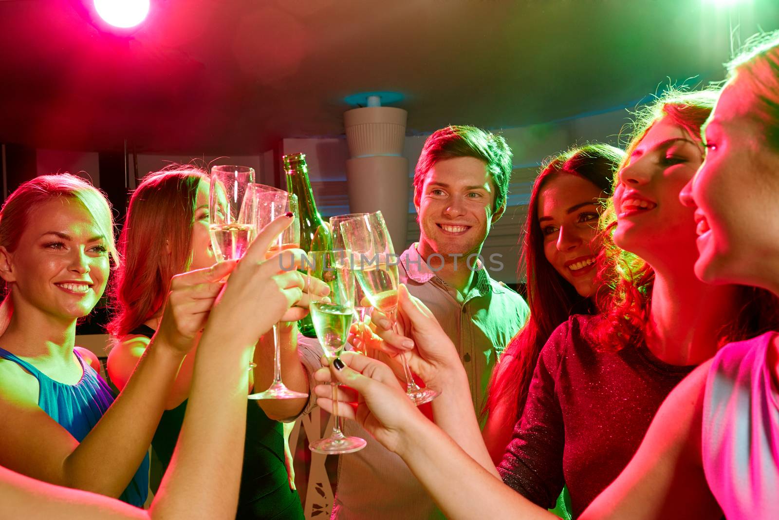 party, holidays, celebration, nightlife and people concept - smiling friends clinking glasses of champagne and beer in club