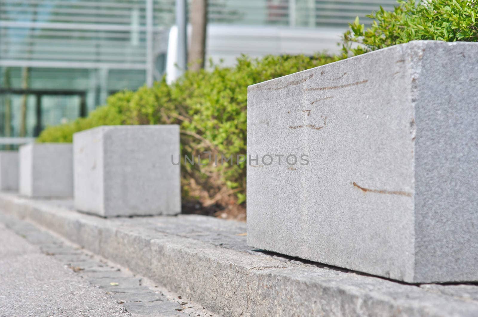 rectangular granite fence in front of bushes