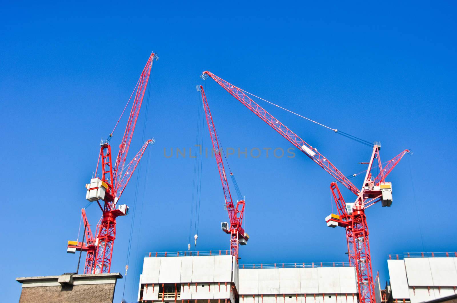 red construction  cranes on blue sky background