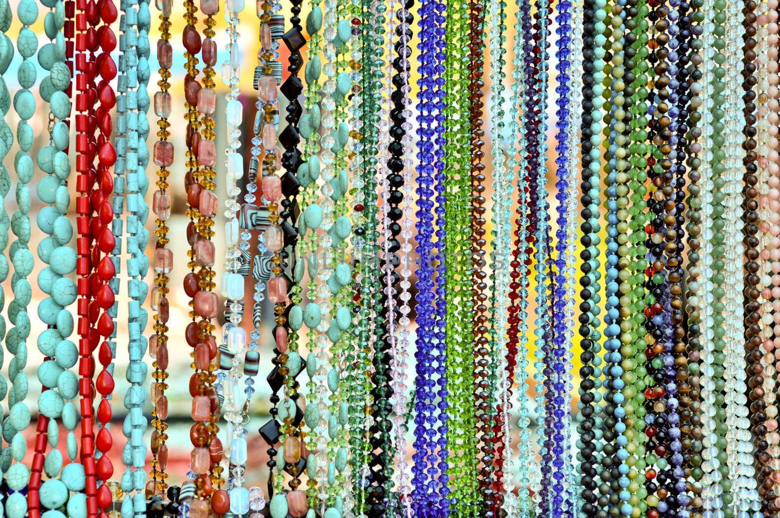 lots of colorful glass and stone beads hanging in a row