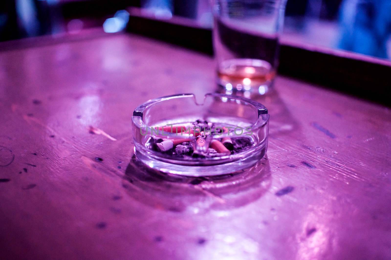 glass and an ashtray on the table