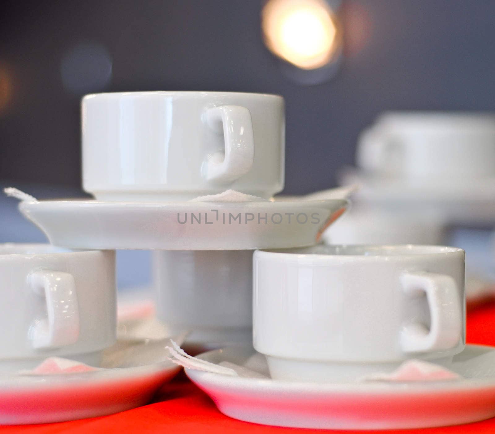 three white porcelain tea cups and saucers and napkins close up by vlaru