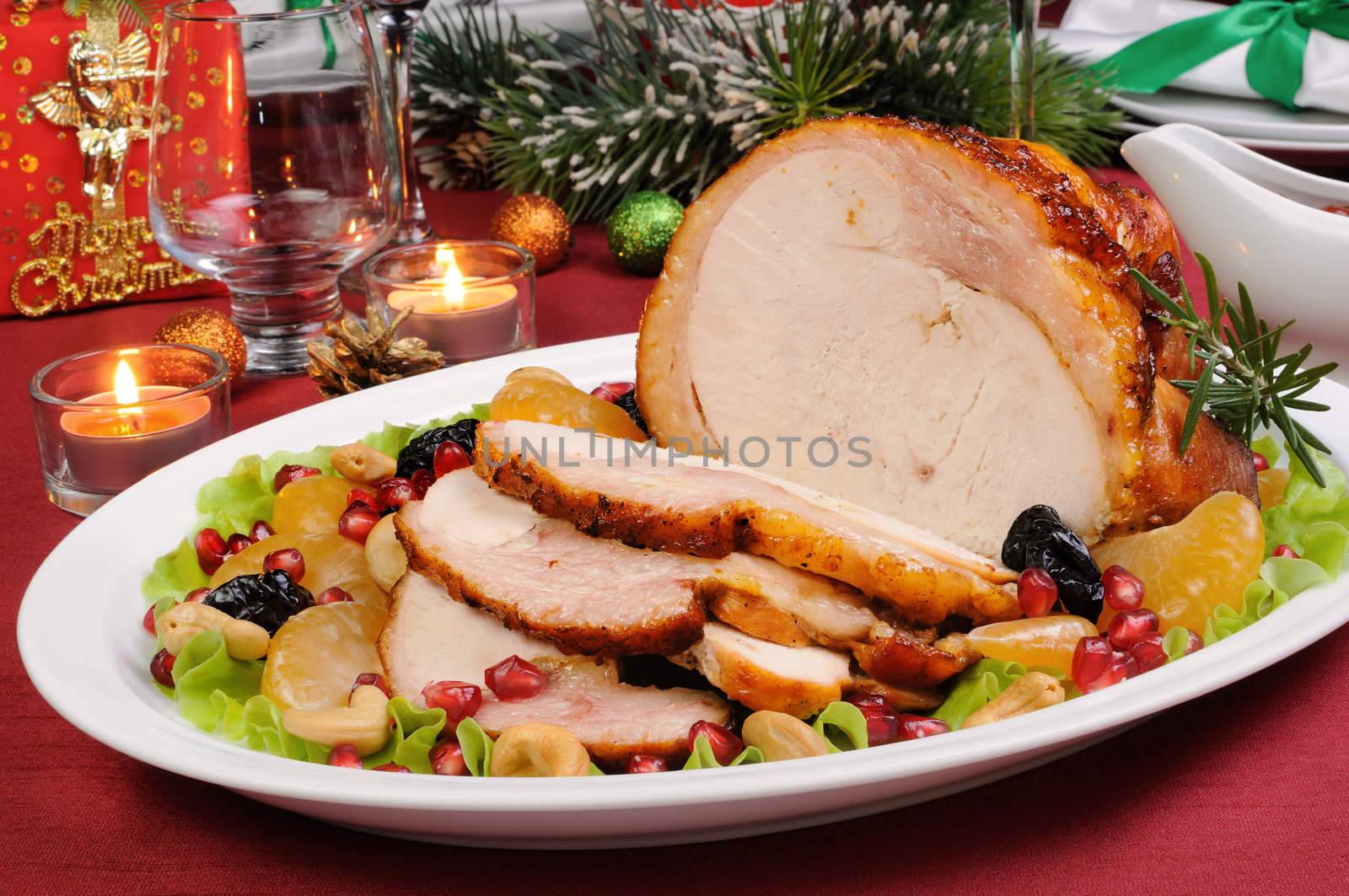 sliced baked turkey ham with fruit garnish on the Christmas table