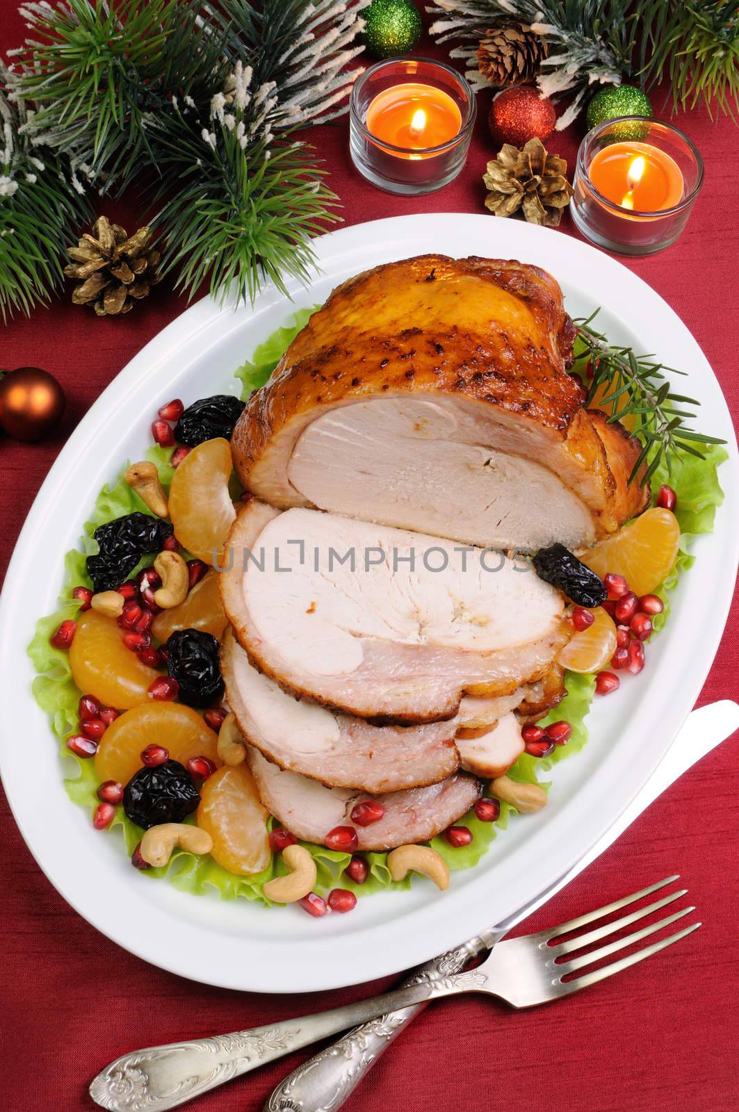 sliced baked turkey ham with fruit garnish on the Christmas table