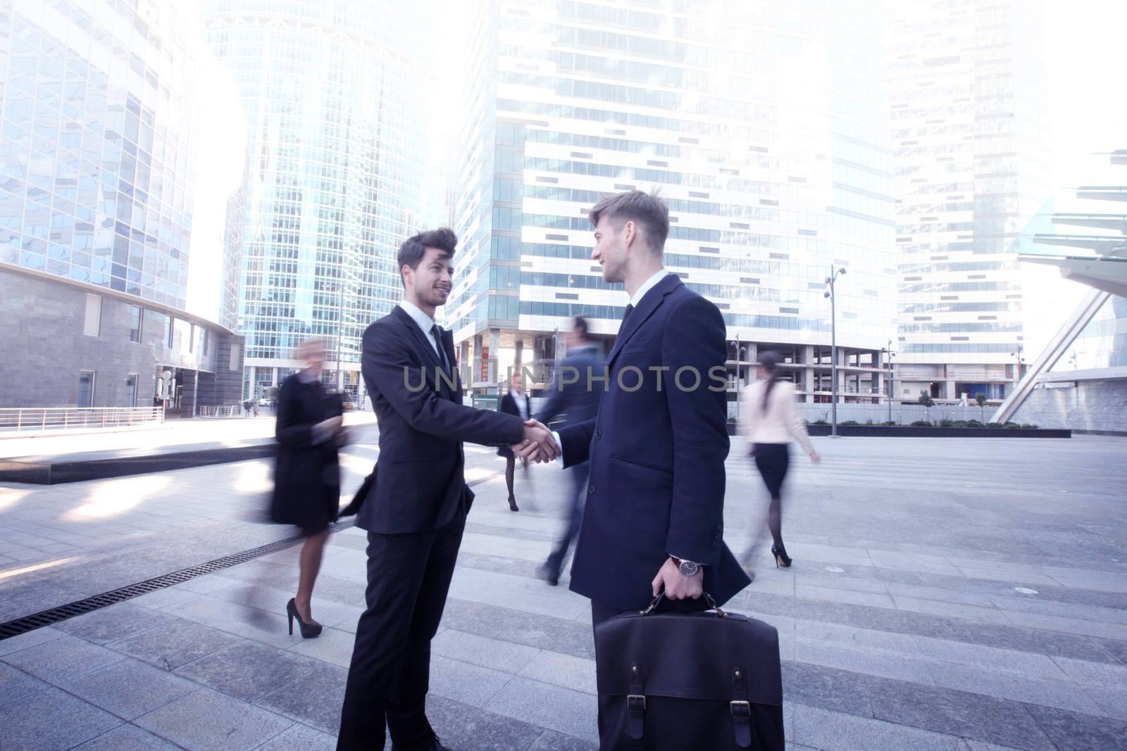 Business people shaking hands, finishing up a meeting outside office