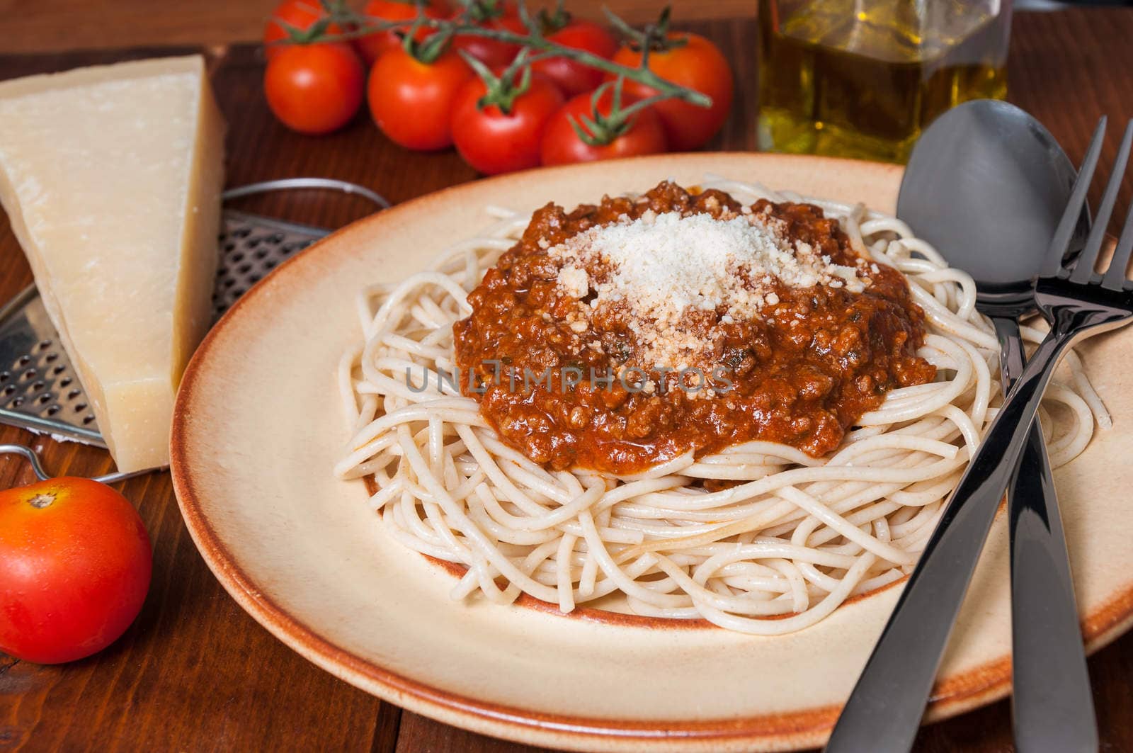 Plate of spaghetti bolognese, cheese, tomatoes and olive oil