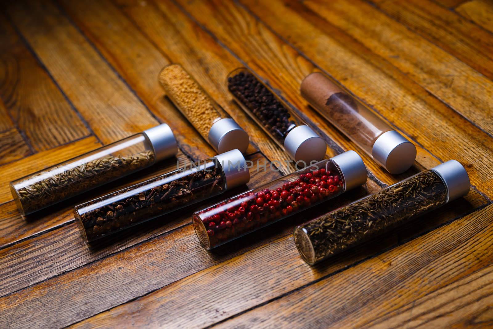 Assorted ground spices in bottles on wooden background